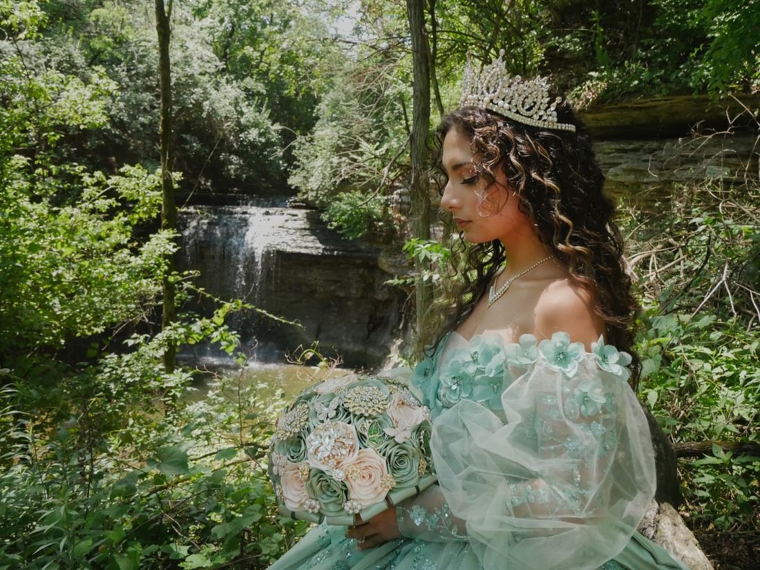 Quinceañera junto a una cascada en el bosque